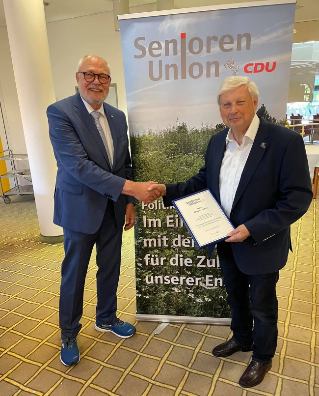Rainer Hajek berreicht die Ehrennadel an Werner Lange (rechts)